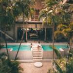man and woman swimming at pool surrounded by trees
