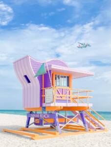 a lifeguard stand on the beach with a plane in the background