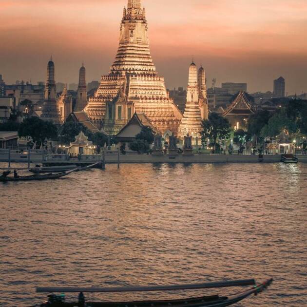 a boat in the water with a large building in the background
