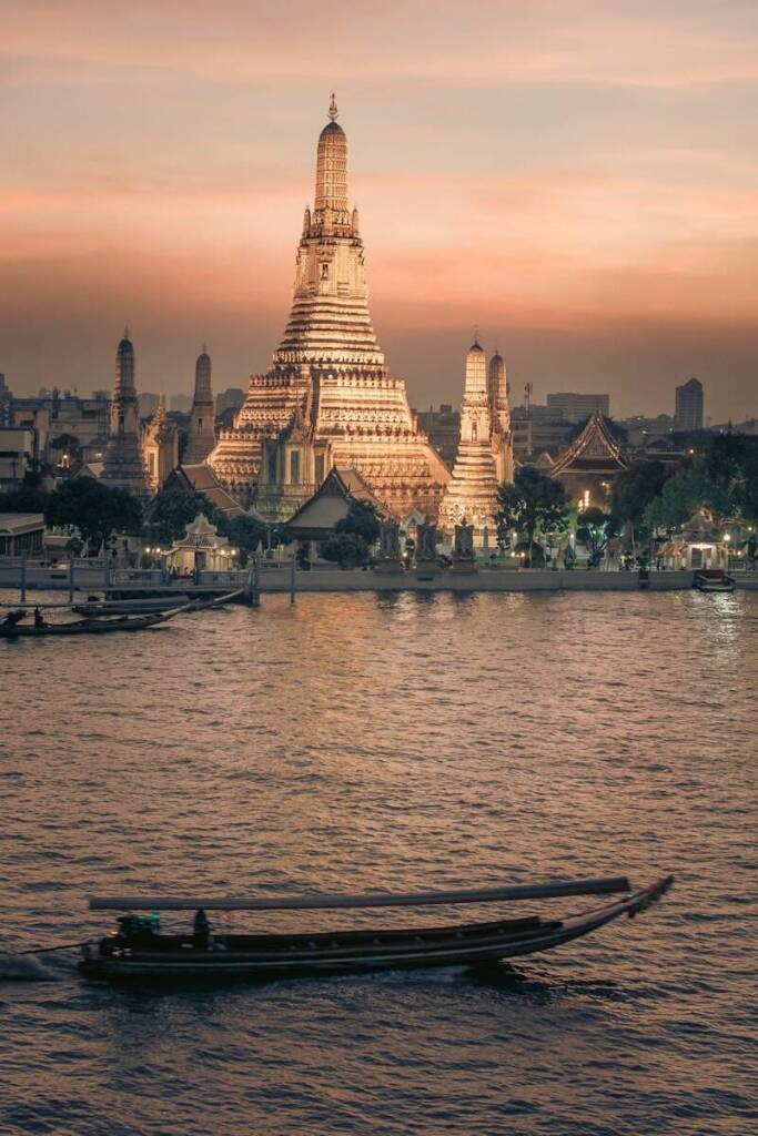 a boat in the water with a large building in the background