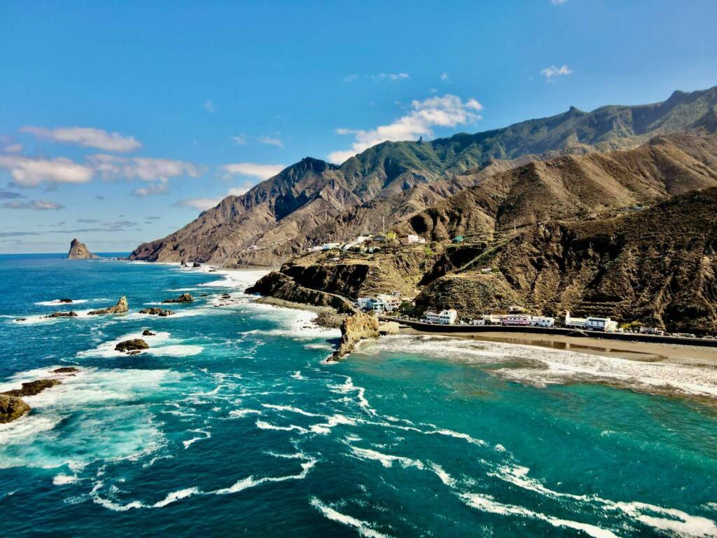 a scenic view of the ocean with mountains in the background